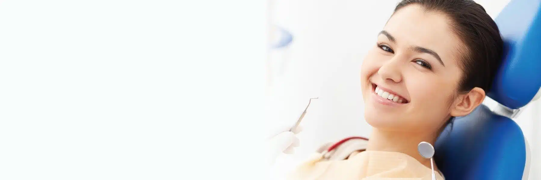 Smiling woman in dental chair during examination at Groves Dental Care clinic