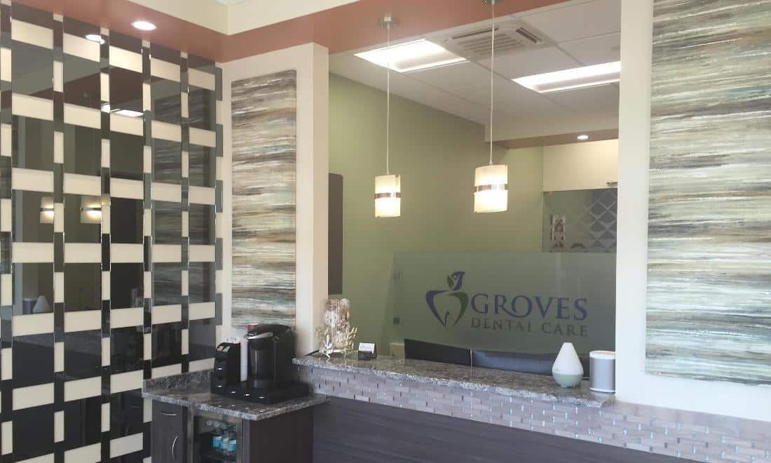 Modern dental office reception area with black and white tile wall and glass entry doors.