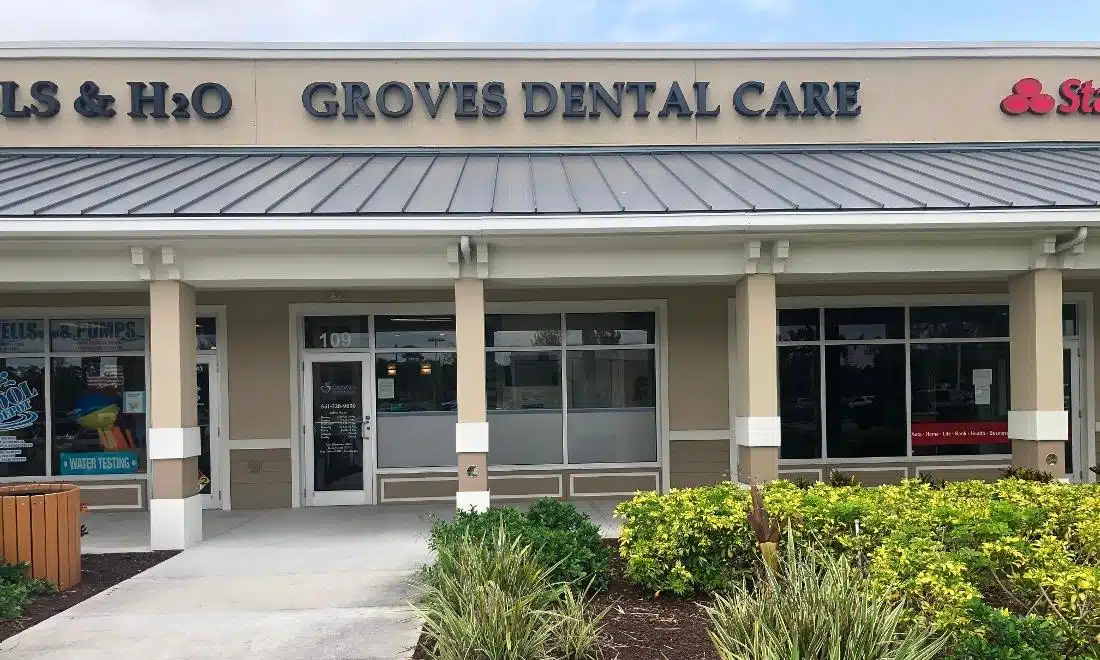 Exterior storefront of Groves Dental Care dental office with entrance and signage.