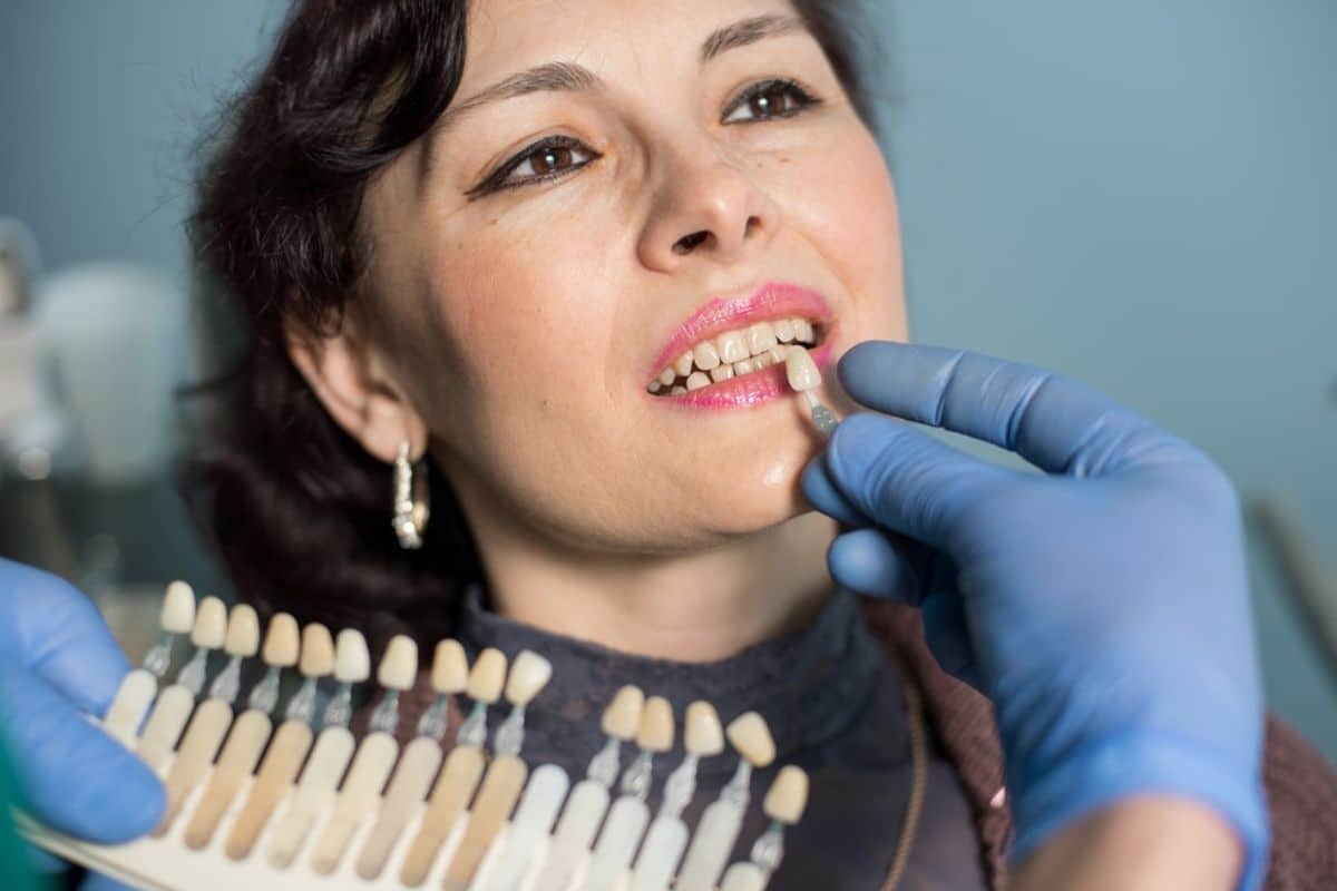 Dental professional examining patient's teeth during routine checkup at dental clinic.